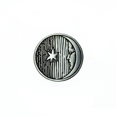 A silver metal moon-with-a-face pin, with antique artwork from the Flammarion Engraving.