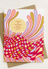 A greeting card reading "here's to another year of being alive".
