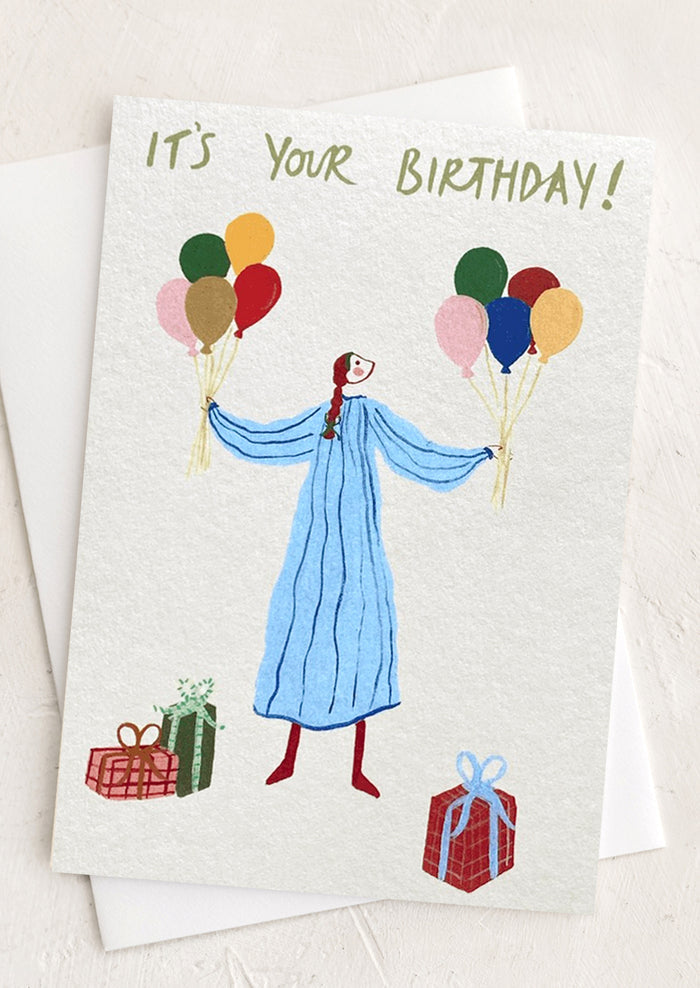 A greeting card with illustration of girl holding balloons, text reads "It's your birthday!".