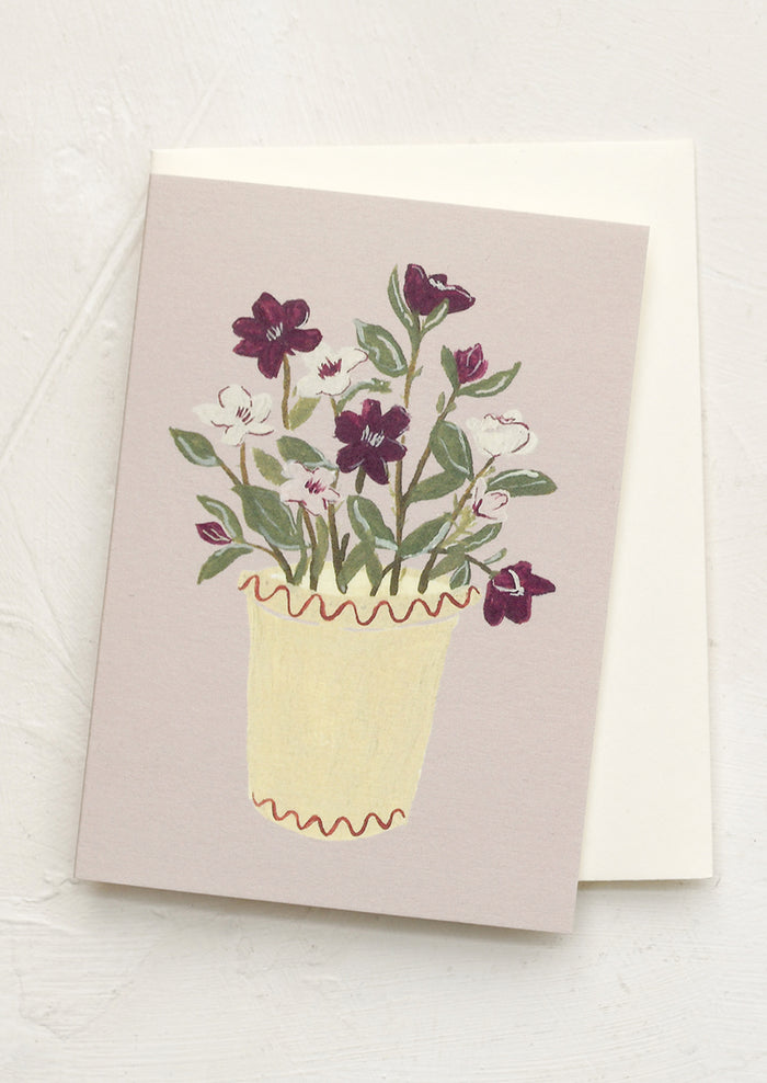 A mini greeting card in mauve with illustration of hellebores in pot.