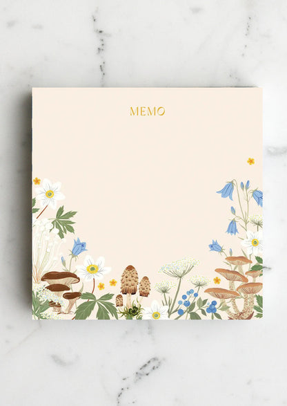 A chunky square notepad reading "MEMO" at top with mushroom floral print at bottom.