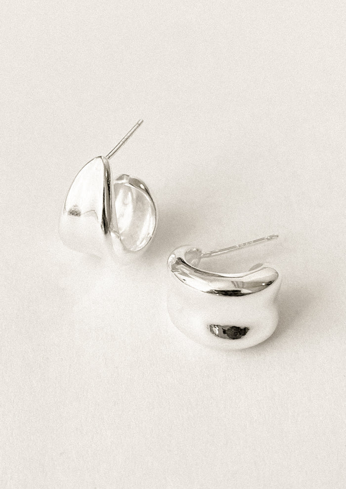 A pair of sterling silver hoop earrings with curled side detail.