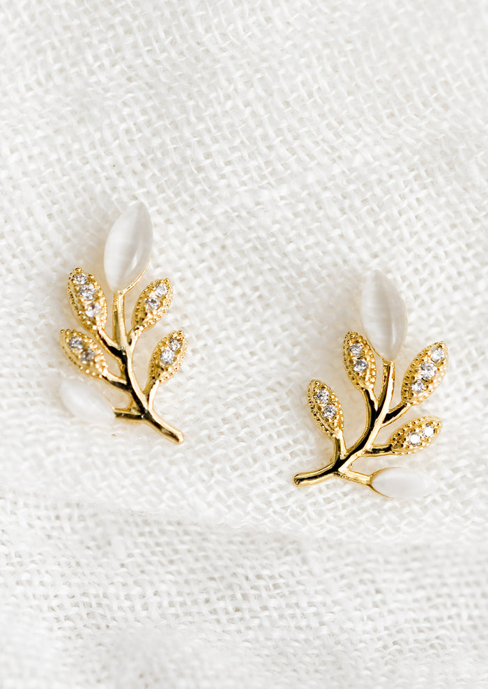 A pair of gold leaf shaped studs with crystal and gemstone "leaves".