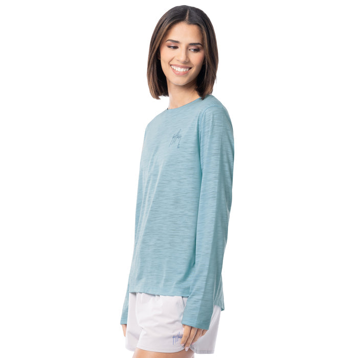 Woman wearing a light blue long-sleeve shirt and white shorts on a white background