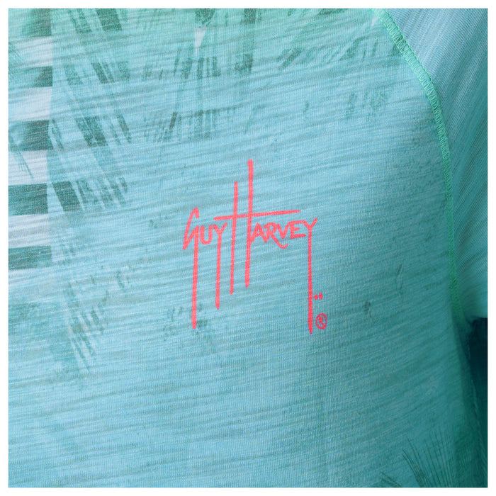 Close-up of a Guy Harvey logo on a textured green surface