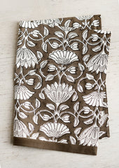 A dark brown and white lotus printed tea towel.