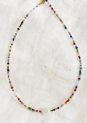 A multicolor seed bead necklace with single pearl at center front.