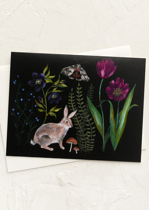 An illustrated greeting card with flora and fauna on black background.