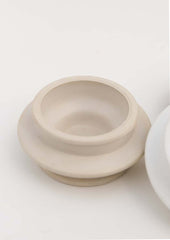 An architecturally shaped tealight holder in sand.