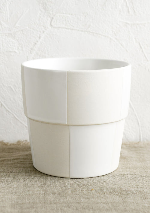 A large cream and white checker patterned planter pot.